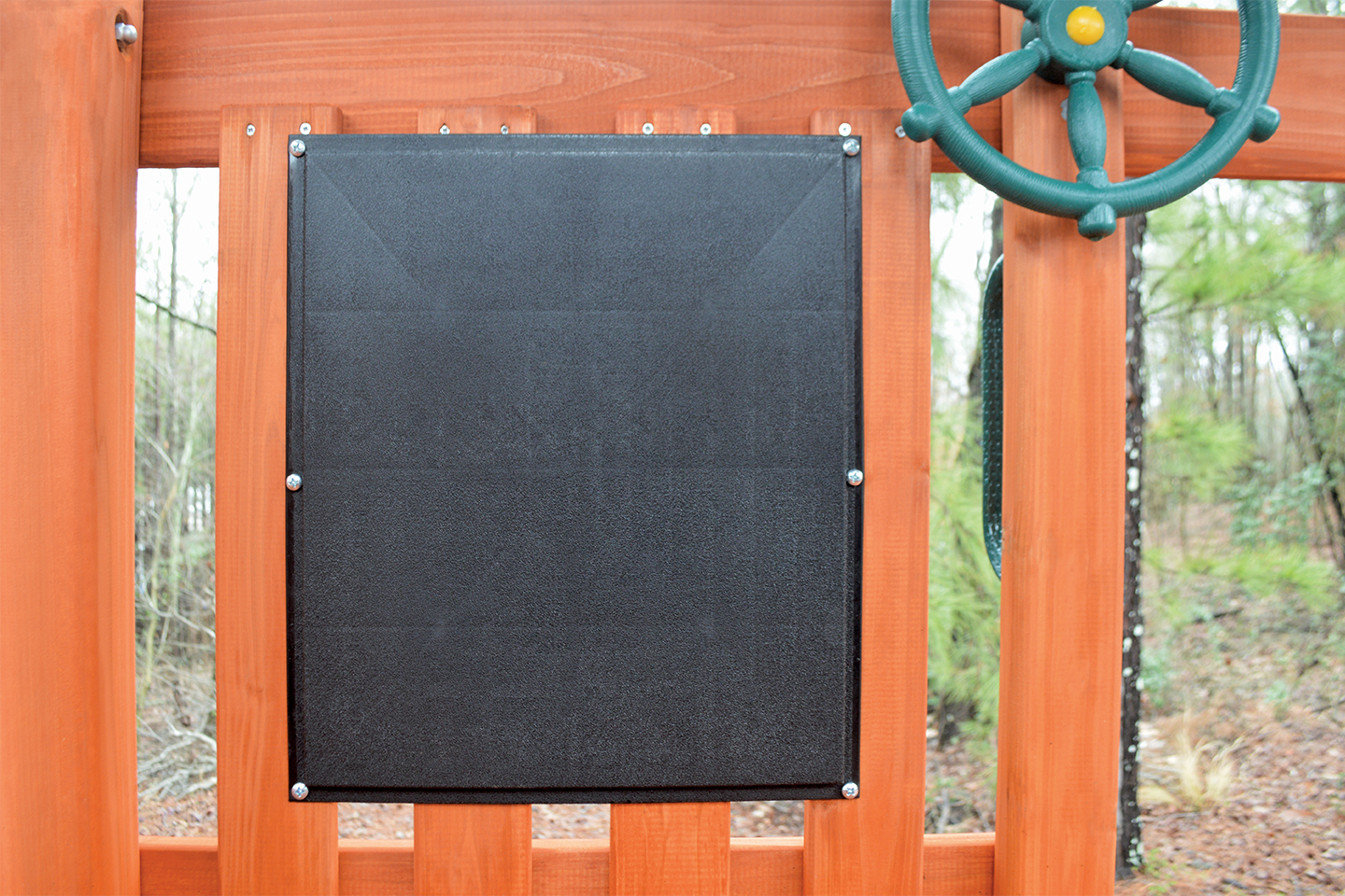 a black board on a wooden fence